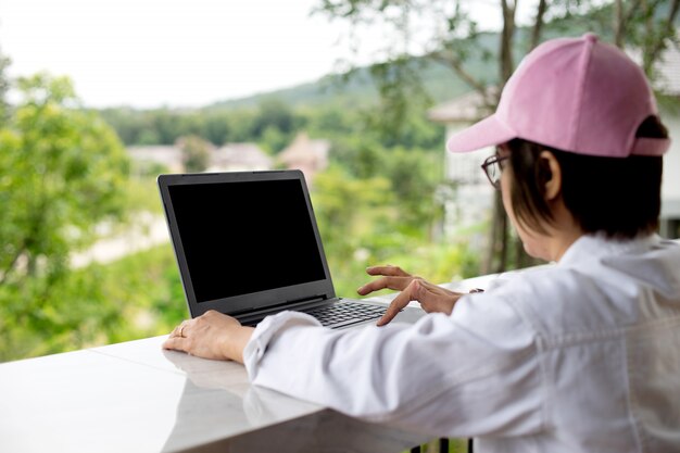 Mulher trabalhando fora de seu escritório quando ela tem vaction no resort, mas pode trabalhar em seu laptop conceito freelance