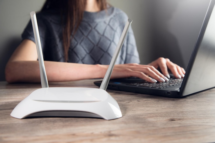 Foto mulher trabalhando no computador com roteador wifi
