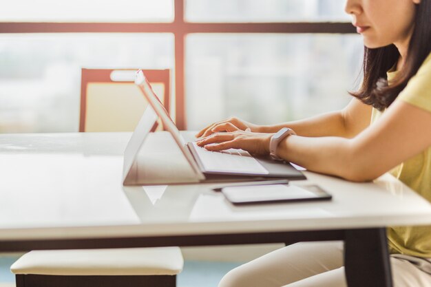 Mulher trabalhando no escritório digitando no teclado do computador