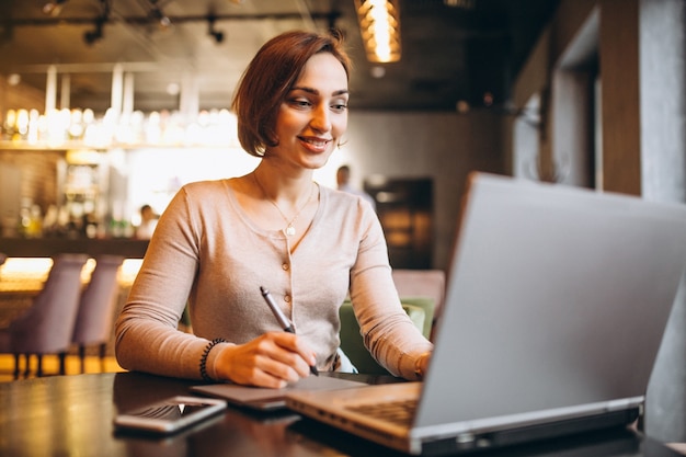 Mulher trabalhando no laptop em um café