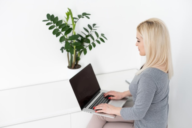 mulher trabalhando no laptop online em home office.
