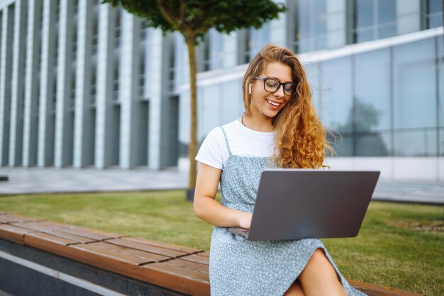Mulher trabalhando on-line em computador portátil ao ar livre Blogging de negócios conceito de educação freelance
