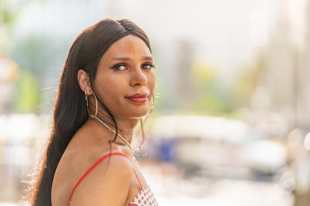 Foto mulher transgênero virando-se para olhar para a câmera ao ar livre