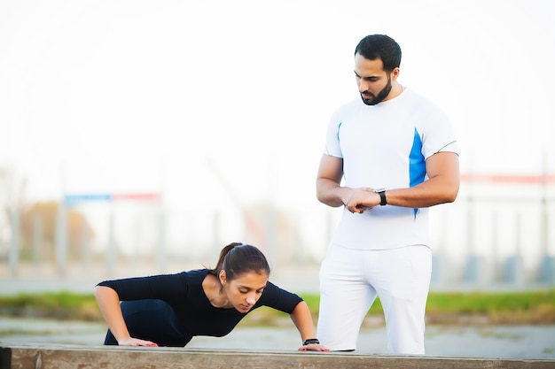 Mulher treinando com personal trainer no parque