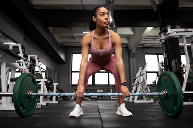 Foto mulher treinando para levantamento de peso no ginásio