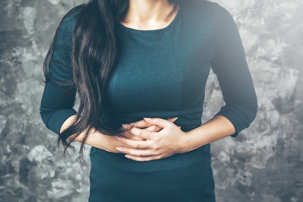 Mulher triste com a mão na barriga