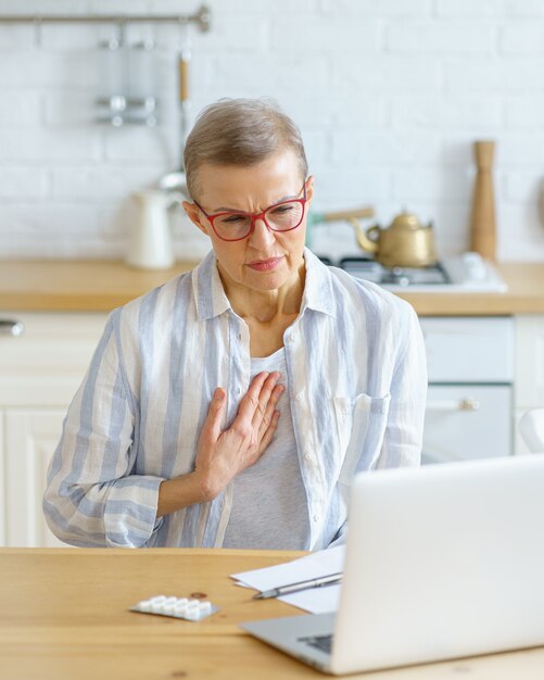 Mulher triste, doente de meia-idade, com dor no peito ou tosse, após consulta online com