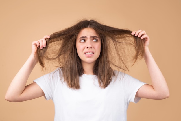 Mulher triste olhando para cabelos danificados o problema de perda de cabelo estúdio isolado espaço de cópia de retrato