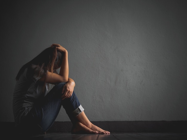 Foto mulher triste sentada sozinha, abraçar o joelho e chorar.