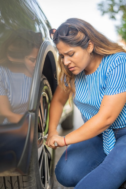 Foto mulher trocando o pneu do carro