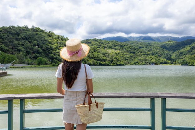 Mulher turista a caminhar à beira do lago