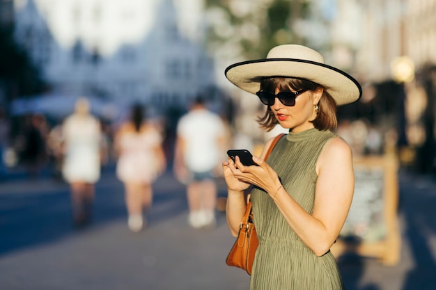 Mulher turista com celular andando na cidade em um dia ensolarado