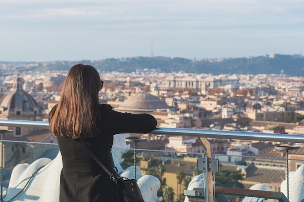 Mulher turista está olhando a cidade de Roma de um ponto alto