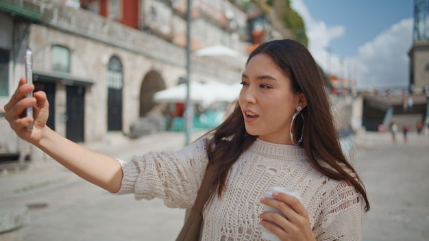 Mulher turista fazendo selfie com café em vista da cidade em closeup morena posando