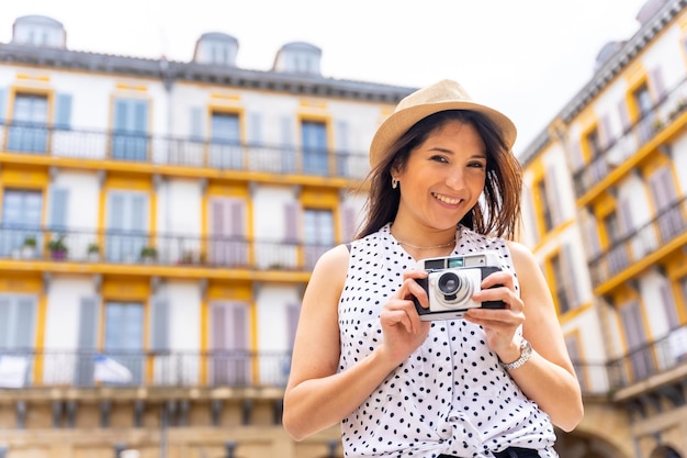 Mulher turista gostando de visitar a cidade olhando fotos de viagens aproveitando o conceito de viajante feminina de férias de verão e criador de conteúdo digital