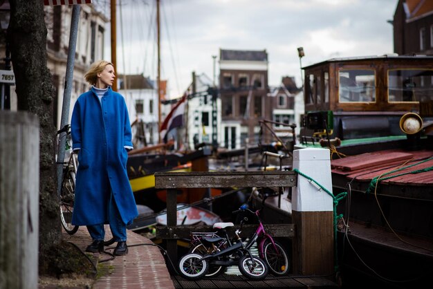 Mulher turista na baía com navios na Holanda Cityscape of Rotterdam Travel and adventure