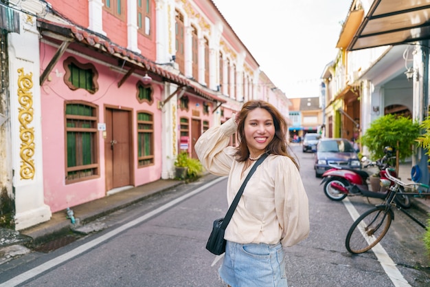 Mulher turista na rua da cidade velha de phuket com arquitetura do edifício sino português na cidade velha de phuket