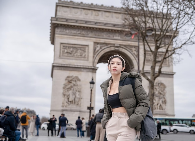 Foto mulher turista no fundo do famoso arco do triunfo inverno ou outono na europa paris frança