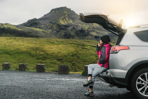 Mulher turista viaja de carro SUV na Islândia