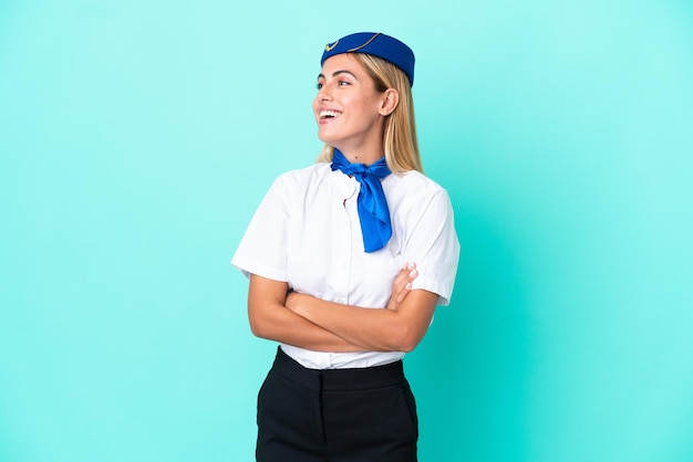 Mulher uruguaia aeromoça isolada em fundo azul feliz e sorridente