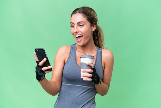 Mulher uruguaia bonita esporte sobre fundo isolado segurando café para levar e um celular