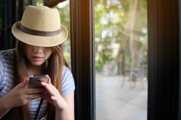 Mulher, usado, smartphone, em, loja café, ao lado, janelas