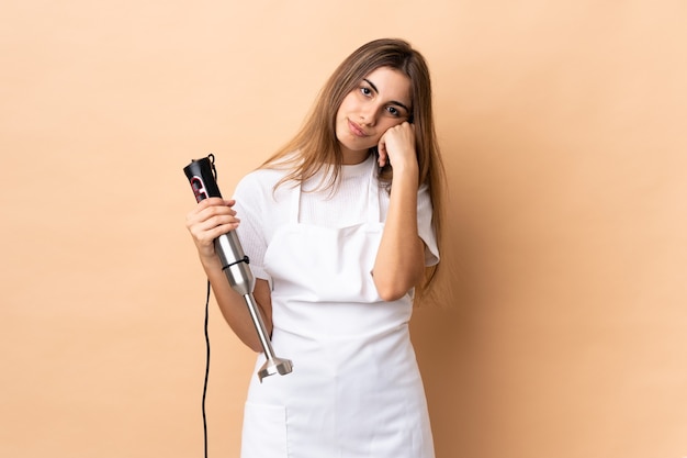 Mulher usando a varinha mágica sobre uma parede isolada com expressão de cansaço e tédio