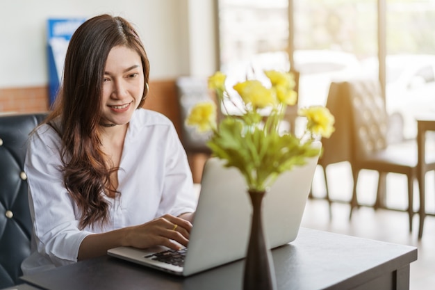 Mulher usando computador portátil no café