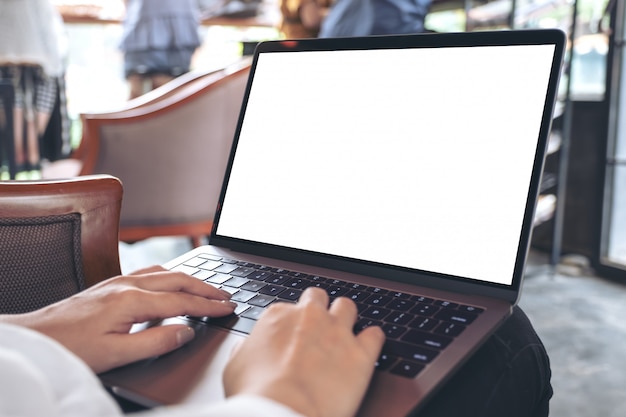 Mulher usando e digitando no laptop com tela branca em branco