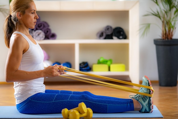 Mulher usando elástico para alongamento após o treino