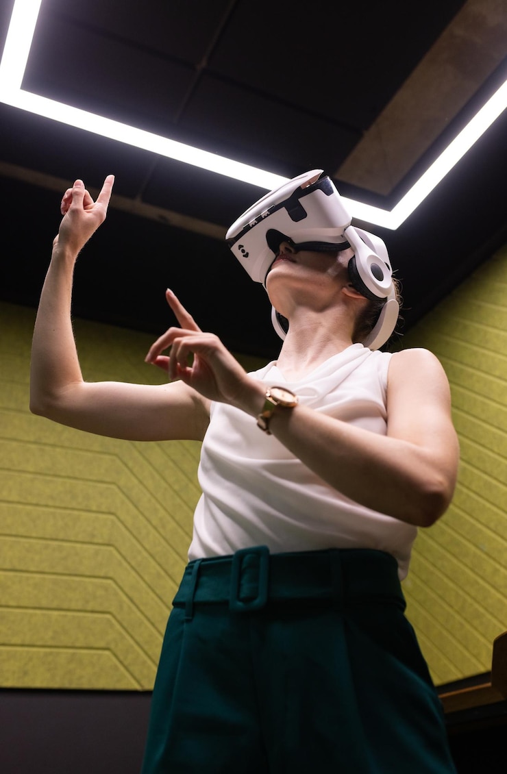 Foto mulher usando fone de ouvido vr interagindo com ambiente virtual em escritório moderno