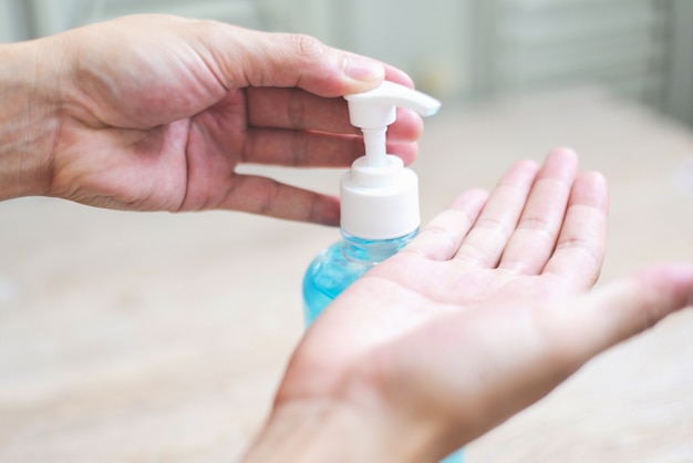 Foto mulher usando frasco com gel antibacteriano