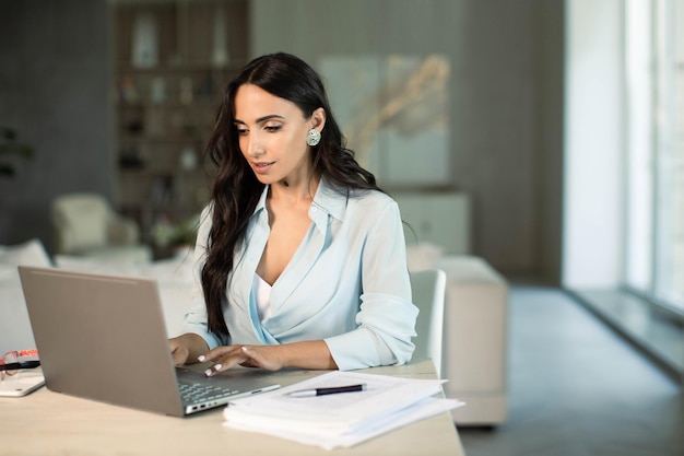 Foto mulher usando laptop dentro de casa no escritório em casa