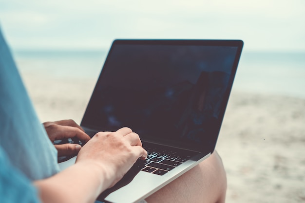 Mulher usando laptop e smartphone em férias