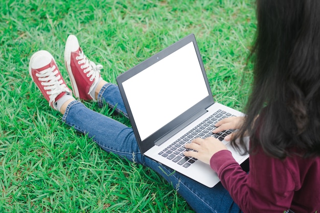 Mulher, usando, laptop, ligado, campo verde, fundo