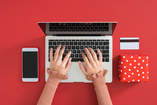 Mulher usando laptop moderno na mesa de cores, vista superior