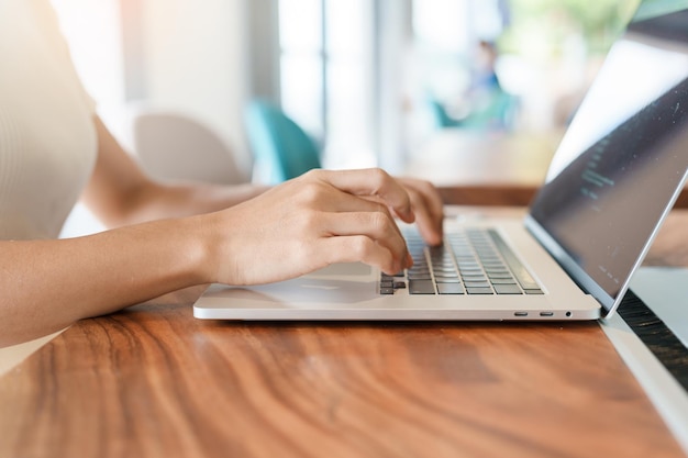 Mulher usando laptop mulher freelance digitando notebook de computador de teclado no café ou tecnologia de escritório moderna digital on-line e conceito de rede