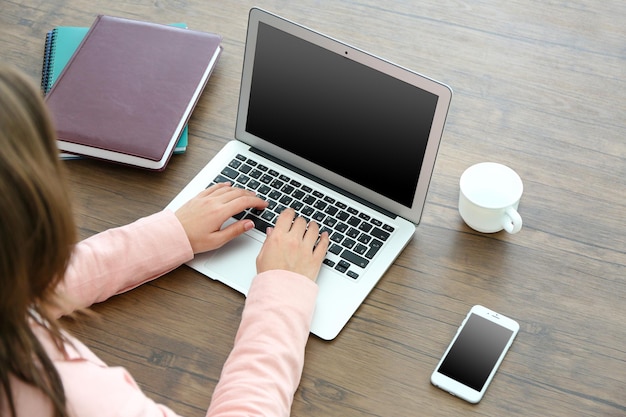 Mulher usando laptop na mesa no escritório