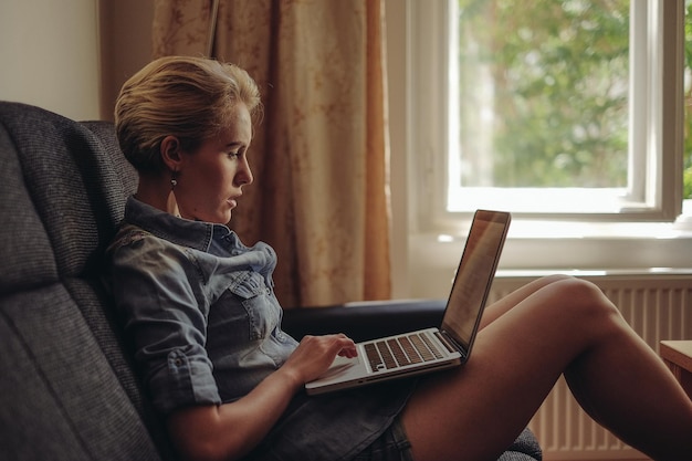 Mulher usando laptop no sofá