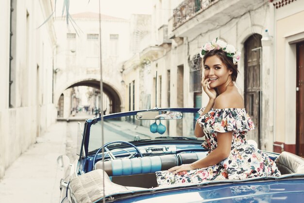 Mulher usando lindo vestido e carro conversível retrô na cidade de Havana