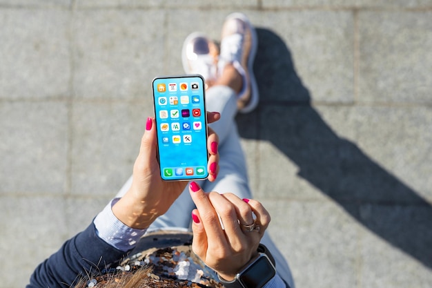 Mulher usando maquete de tela inicial de celular com ícones de aplicativos