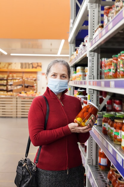 Mulher usando máscara facial comprando e escolhendo produtos no supermercado