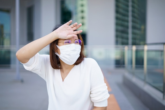 Mulher usando máscara facial protege o filtro contra a poluição do ar (pm2.5) ou usa máscara n95. proteger a poluição, anti smog e vírus, a poluição do ar causou problema de saúde. conceito de poluição ambiental.