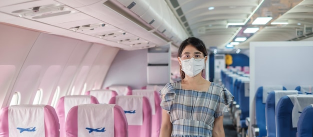 Mulher usando máscara facial protetora sentada em avião ou transporte público, proteção contra infecção por doença de coronavírus, turista pronto para viajar. Próximo Normal, turismo e conceito de reabertura