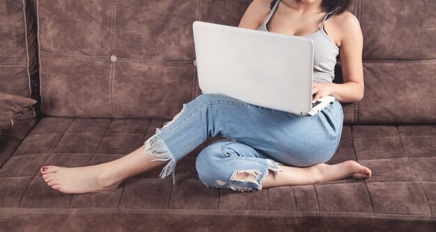 Mulher usando o laptop branco em casa.