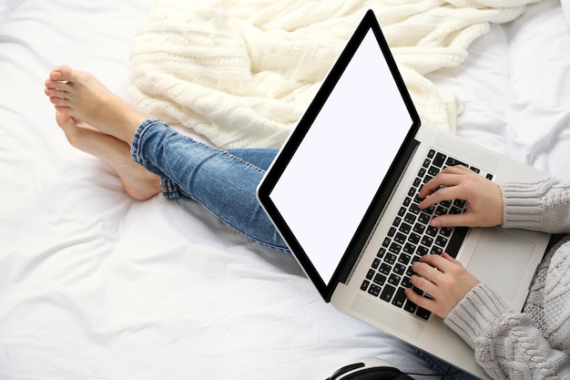 Mulher usando o laptop na cama