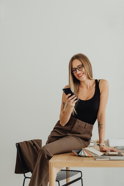 mulher usando o telefone fazendo uma pausa no trabalho no escritório de trabalho do computador