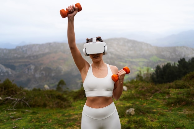 Foto mulher usando óculos vr para se exercitar ao ar livre com pesos