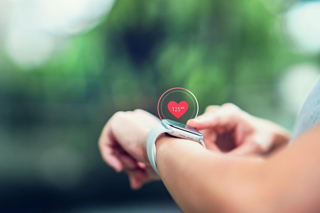 Mulher usando relógios inteligentes com verificação de pulso através de aplicativo de saúde