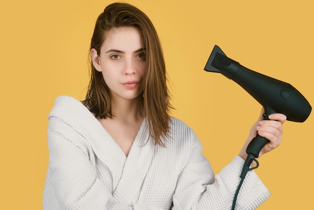 Mulher usando secador de cabelo Moça com cabelo seco com cabelo seco Cuidados com o cabelo feminino